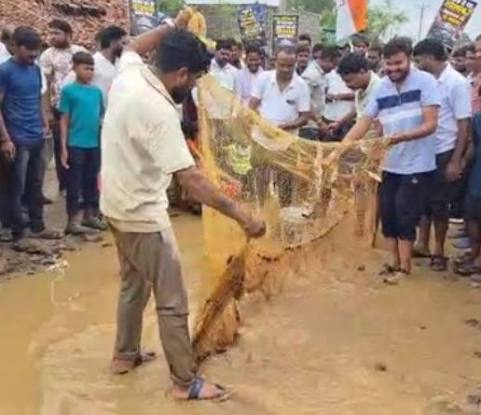 जर्जर सड़क पर कांग्रेस का अनोखा प्रदर्शन, गड्ढों में जाल डालकर पकड़ी मछली; 30 करोड़ की सड़क पांचवें टेंडर के इंतजार में